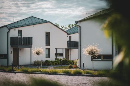 a row of white houses with black roofs at Hercegasszony Birtok in Mezőtúr