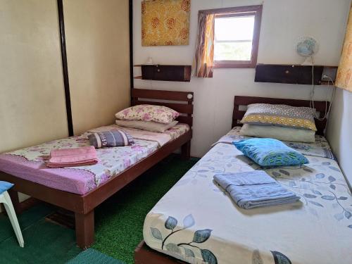 two twin beds in a room with a window at Genevieve Guest House in Maria