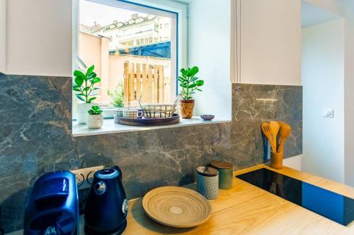 une cuisine avec une fenêtre et un comptoir en bois dans l'établissement Le jardin de l'hyser, à Strasbourg