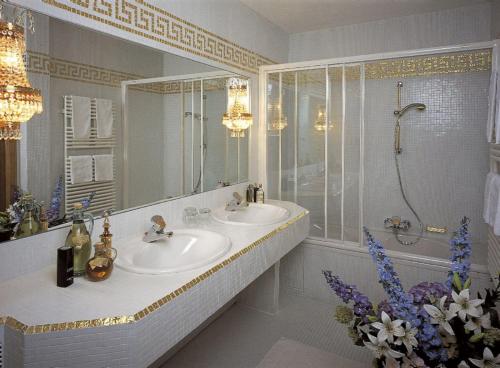 a bathroom with two sinks and a large mirror at Schloss Hotel Fernsteinsee in Nassereith