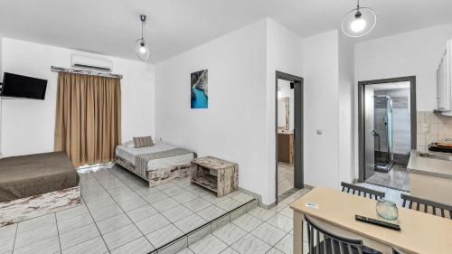 a living room with a bed and a kitchen at Erato Hotel in Kokkíni Khánion