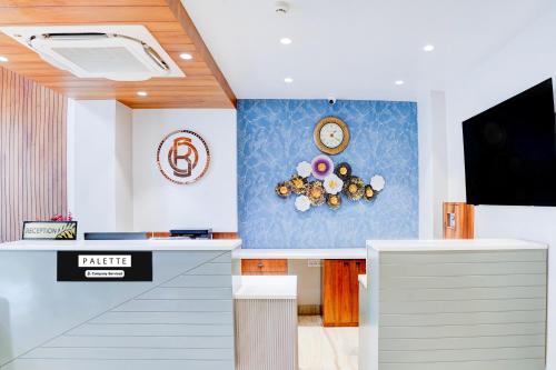 a living room with a clock and a tv at Palette Patel Nagar in Bhopal