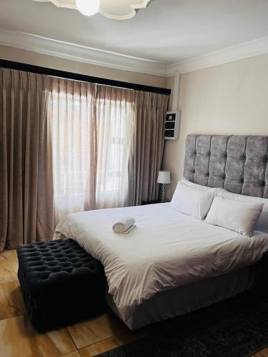 a bedroom with a large bed and a large window at Papiano Boutique Hotel in Bloemfontein