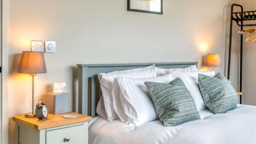 a bedroom with a bed with white pillows at Downs in Blewbury
