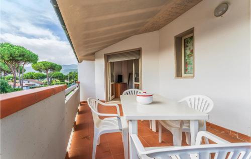 a balcony with a white table and chairs at Bilo 5 in Orbetello
