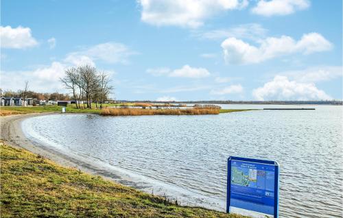 a sign in the grass next to a body of water at Pet Friendly Home In Lauwersoog in Lauwersoog
