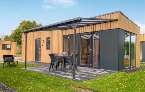 a shed with a table and chairs in a yard at Awesome Home In Heinkenszand With Wifi in Heinkensand