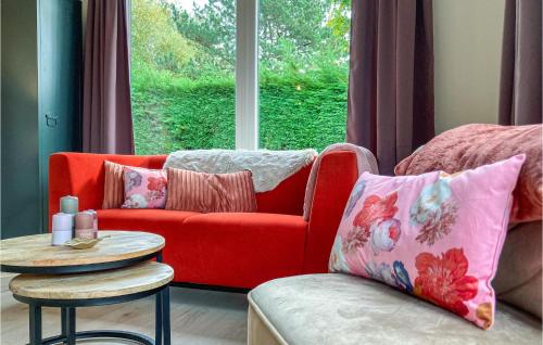 a living room with a red couch and a table at Awesome Home In Heinkenszand With Wifi in Heinkensand