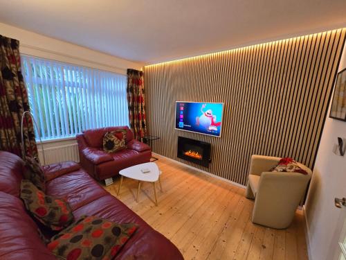 a living room with a couch and a fire place at Port Tara Holiday Home in Portballintrae