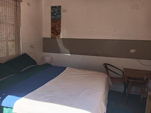 a small bedroom with a bed and a table at Cabaña Nachitor in San Pedro de Atacama