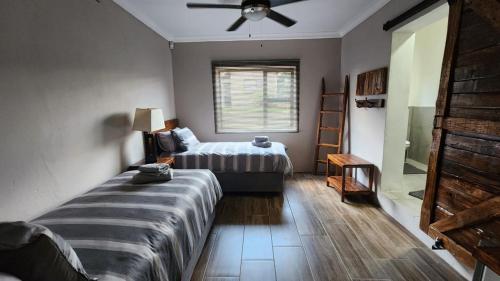 a bedroom with a bed and a window at Twilight Suite in Hekpoort