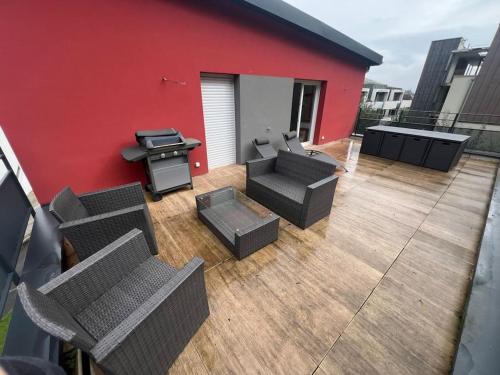 - un patio avec des chaises et un grill dans un bâtiment dans l'établissement Appartement lumineux à 25min de Mulhouse et Colmar, à Soultzmatt