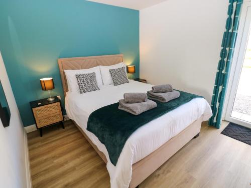 a bedroom with a bed with two towels on it at Lobster Cottage in Saundersfoot