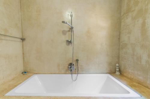 a bath tub in a bathroom with a shower at Hartenbos Breakaway - LightHouse Cottage in Mossel Bay