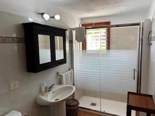 ティハラフェにあるVilla Feliz casa Los Geranios 2の洗面台とガラスのシャワーを備えたバスルーム