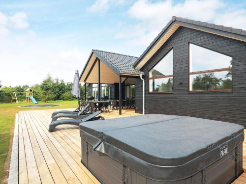 a house with a hot tub on a wooden deck at 5 star holiday home in Højslev in Højslev