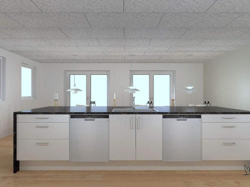 a kitchen with white cabinets and a black counter top at 5 star holiday home in Højslev in Højslev