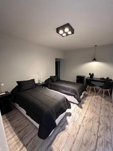 a bedroom with two beds and a table in it at Casagrande Hotel Boutique in Tinogasta