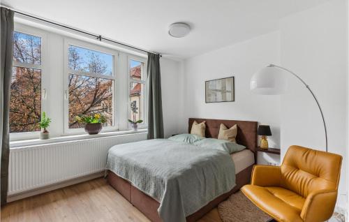a bedroom with a bed and a chair and windows at Pet Friendly Apartment In Naumburg in Naumburg