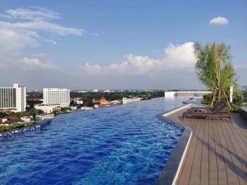 une grande piscine avec une ville en arrière-plan dans l'établissement The Astra Sky River 2 bedrooms, à Chiang Mai