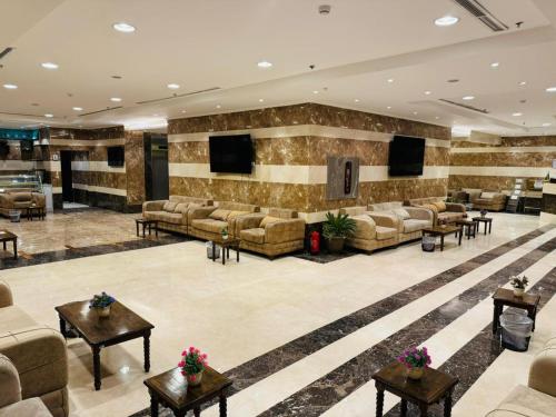 a large lobby with couches and tables and televisions at فندق الركائز in Makkah