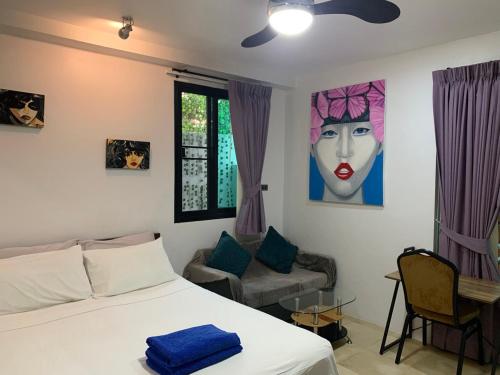 a bedroom with a bed and a painting of a woman at Penthouse Crystal Bay Apartments in Ban Lamai
