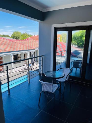 a balcony with a table and chairs and a view at Papiano Boutique Hotel in Bloemfontein