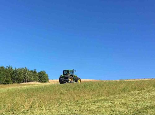 a tractor is sitting in a field of grass at POPPY LUXURY LODGE Sleeps 8 at Fairview Farm, Ravenshead, Nottingham Near Sherwood Forest, Dog Friendly, Farm Stay great for wedding groups, families, Hen Do's, friends gatherings with amazing views in Blidworth