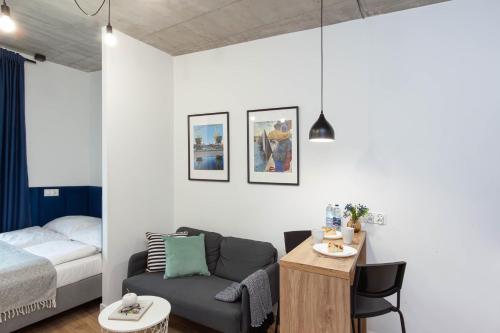 a room with a bed and a couch and a table at Apartamenty Silver Place in Szczecin