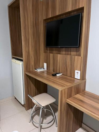 a room with a desk with a tv and a chair at Maximus Sottile Hotel in Ji-Paraná