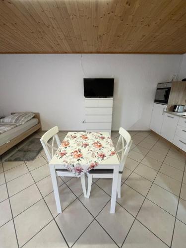 a table and chairs in a room with a kitchen at Ferienwohnungen Schiffmann in Pressath