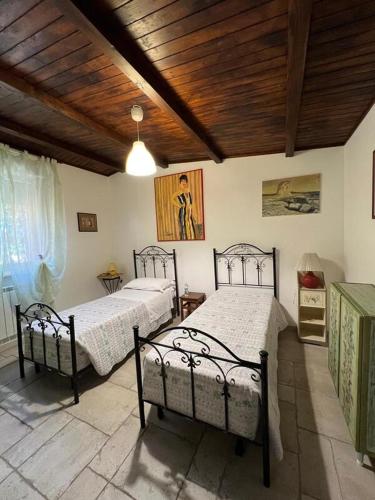 a bedroom with two beds and a wooden ceiling at Villa Marida in Gioia del Colle