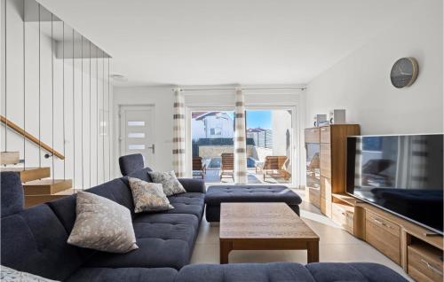 a living room with a blue couch and a tv at 4 Bedroom Awesome Home In Srima in Srima