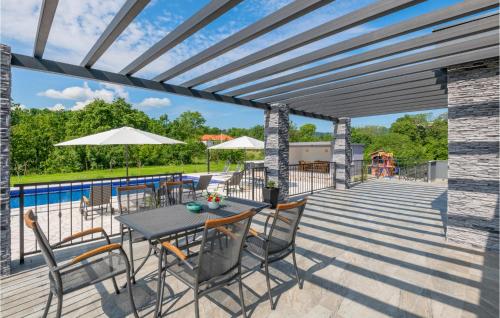 a patio with a table and chairs and a pool at Gorgeous Home In Grubine in Grubine