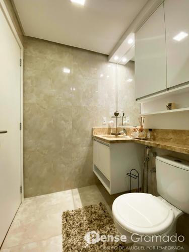 a bathroom with a toilet and a sink at Belluno Boulevard Canela in Canela