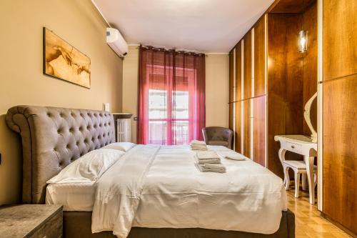 een slaapkamer met een groot bed en een stoel bij Milano Via Morgantini 5 PAX Wi-Fi in Milaan