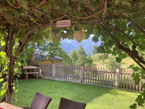 a garden with two chairs and a table and a fence at Ferienhaus Waidmannsruh in Hippach