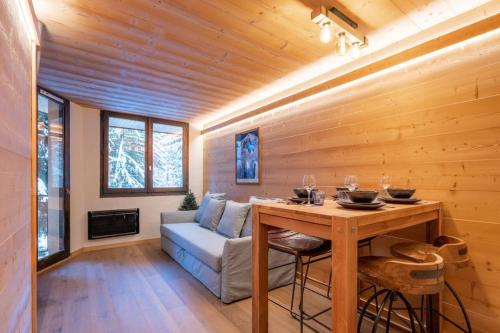 un salon avec une table et un canapé dans l'établissement Chamois Blanc - Quiet Studio close to the town centre - By Cozee Rentals, à Chamonix-Mont-Blanc