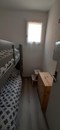 une chambre avec un lit, un bureau et une fenêtre dans l'établissement Appartement T2, terrasse, piscine, clim, proche plage, à Marseillan