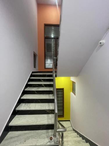 a staircase in a room with orange and yellow walls at VMP Villa Home Stay in Tājganj
