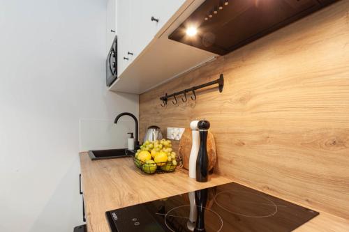 a kitchen with a bowl of fruit on a counter at Apartamenty Silver Place in Szczecin
