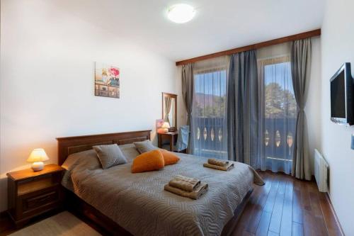 バンスコにあるPirin Golf & Country Club Apartmentのベッドとタオル2枚のある寝室