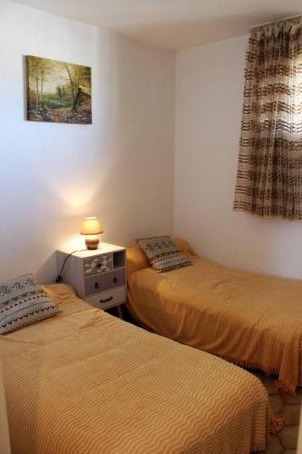 une chambre avec deux lits et une table avec une lampe dans l'établissement Entre le port et le secteur Maillol spacieux T3 tout confort - 6CAL503, à Saint Cyprien Plage
