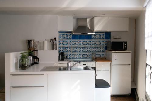 une cuisine avec des armoires blanches et un évier dans l'établissement Sealencieux Gîte 6 à 8 pers à deux pas du port, à Saint-Valery-sur-Somme