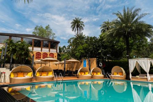 a swimming pool with domed lounges and a resort at Chacha Inn The Garden Retreat in Mount Ābu