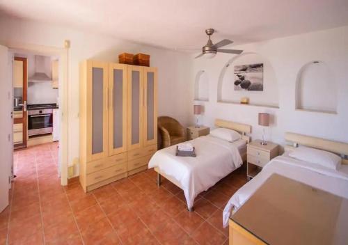 ein Schlafzimmer mit zwei Betten und eine Küche in der Unterkunft Villa Gemma Celebration Haven in Málaga