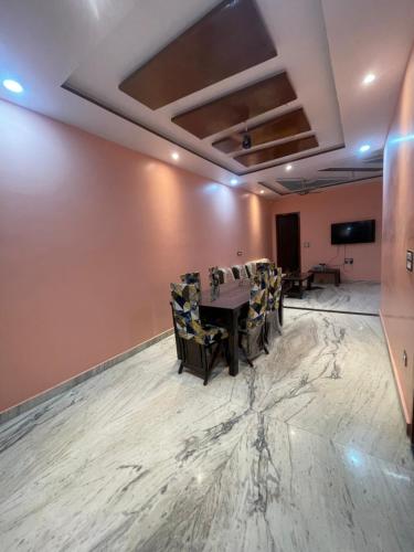 a conference room with a table and chairs and a screen at VMP Villa Home Stay in Tājganj