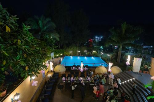 a group of people standing around a stage at night at Chacha Inn The Garden Retreat in Mount Ābu
