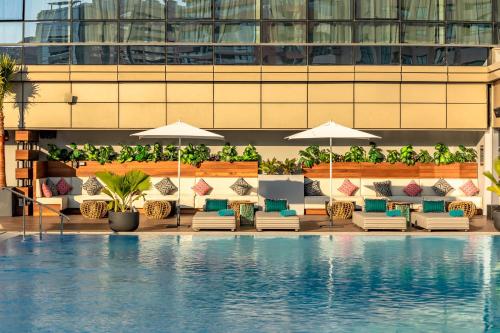 a pool with chairs and umbrellas next to a building at Zabeel House The Greens by Jumeirah in Dubai