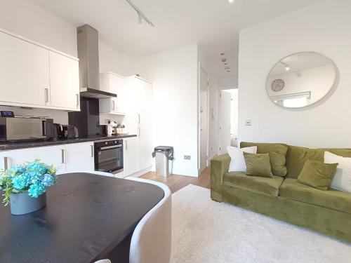 a living room with a green couch and a table at Roof terrace 2BED Property CAMDEN free WiFi in London